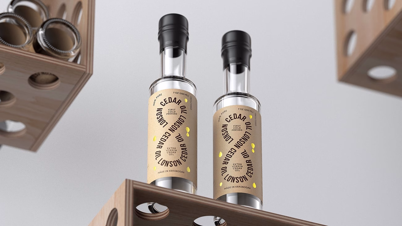 Two glass bottles of cedar oil with kraft paper labels on a wooden shelf. The design features dark typography and yellow accents.