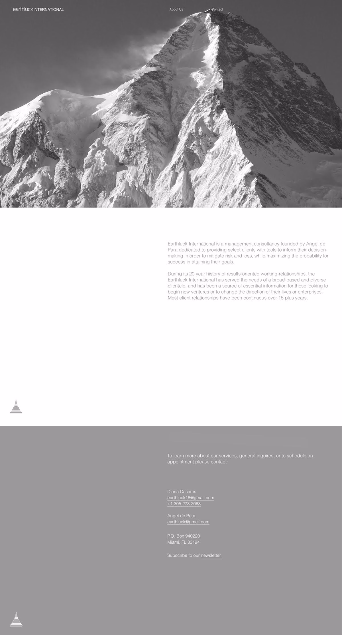 A monochrome mountain peak rises dramatically against a cloudy sky, showcasing jagged icy terrain and sharp edges.