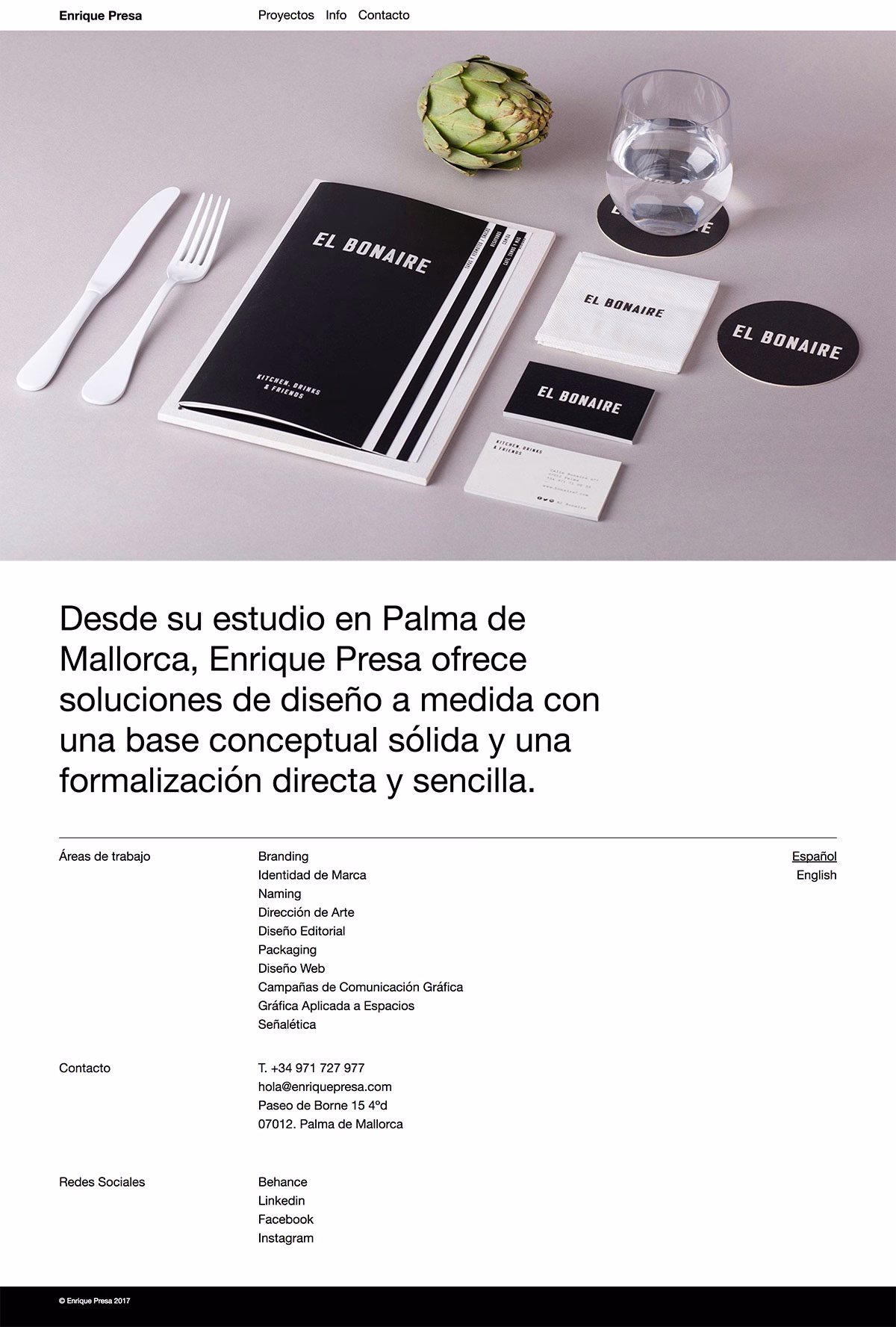 A minimalistic table setting featuring a black menu, a clear glass of water, a fork, and an artichoke.