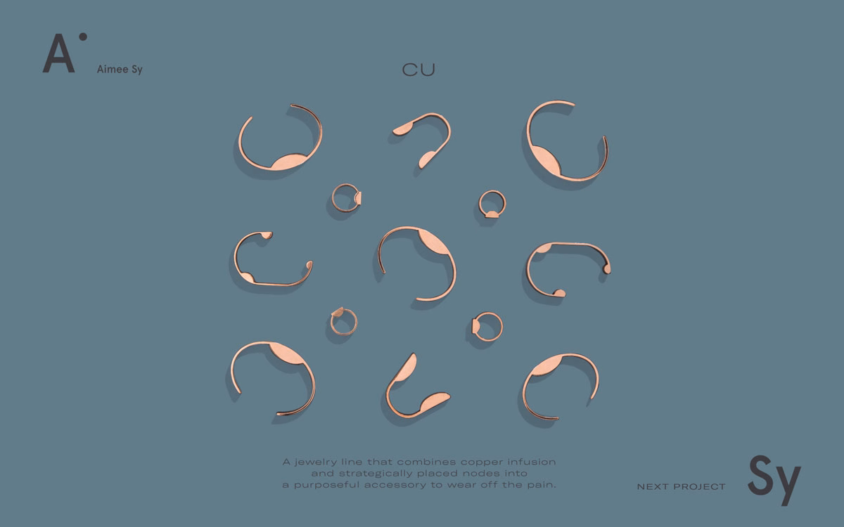 A collection of copper-colored jewelry pieces displayed on a soft blue background, arranged in an organic pattern.