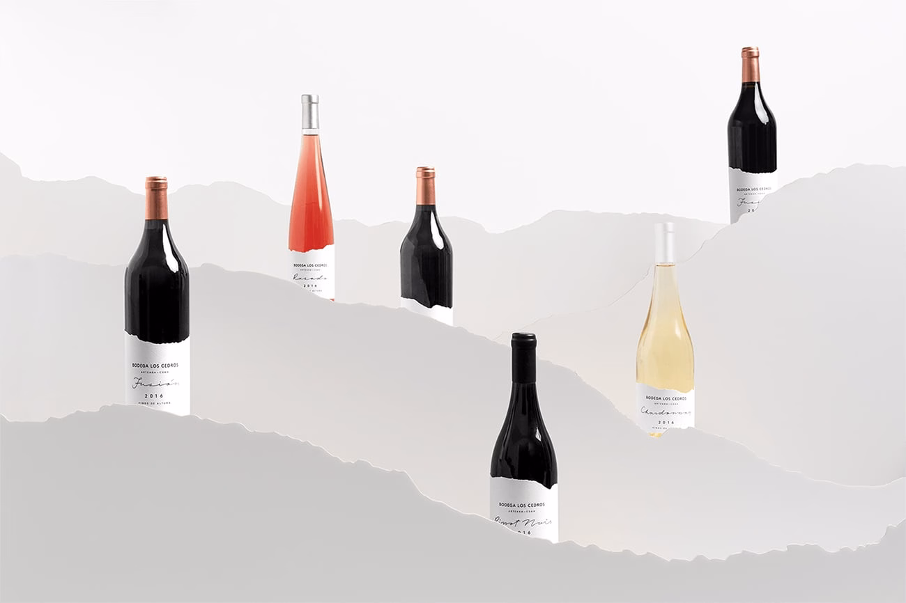 A serene display of wine bottles in various heights, set against a soft, white background with subtle waves.