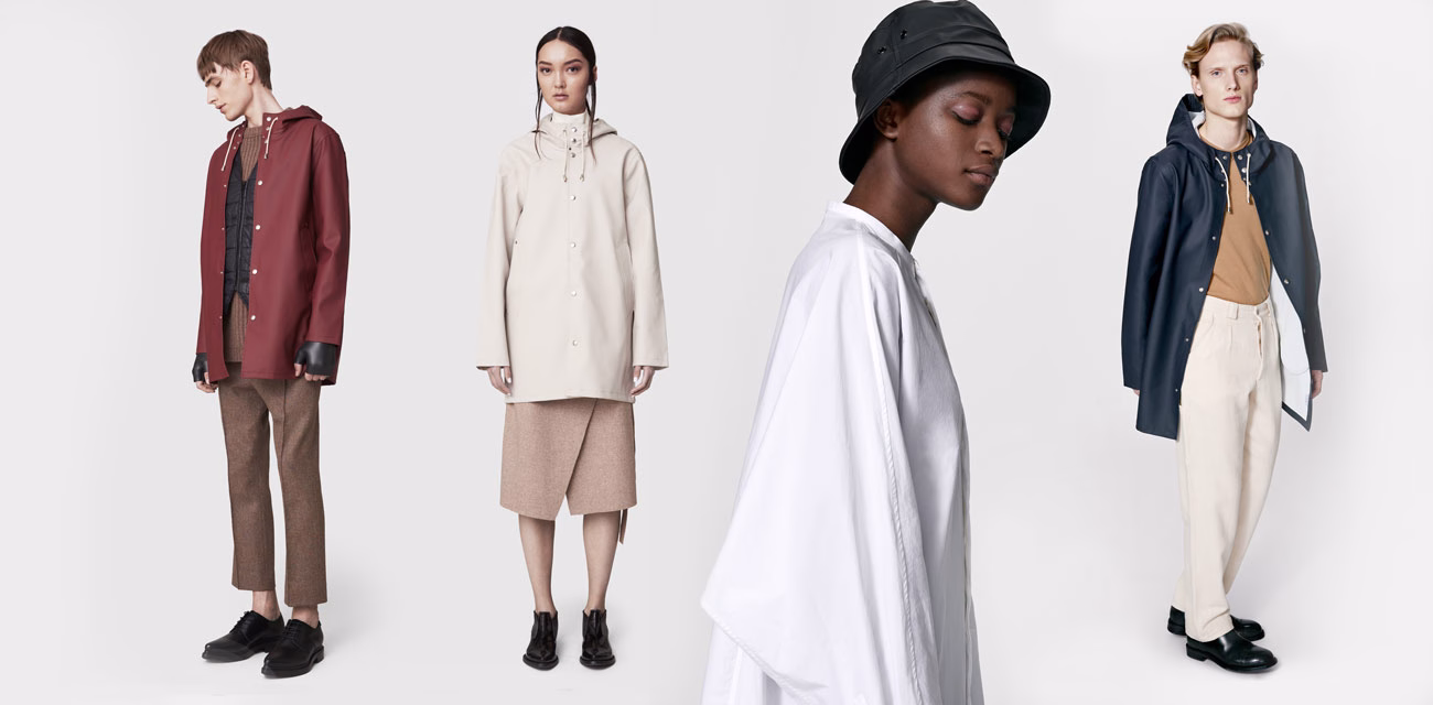Four models showcase contemporary outerwear in neutral tones, featuring minimalist designs and varying fabrics.