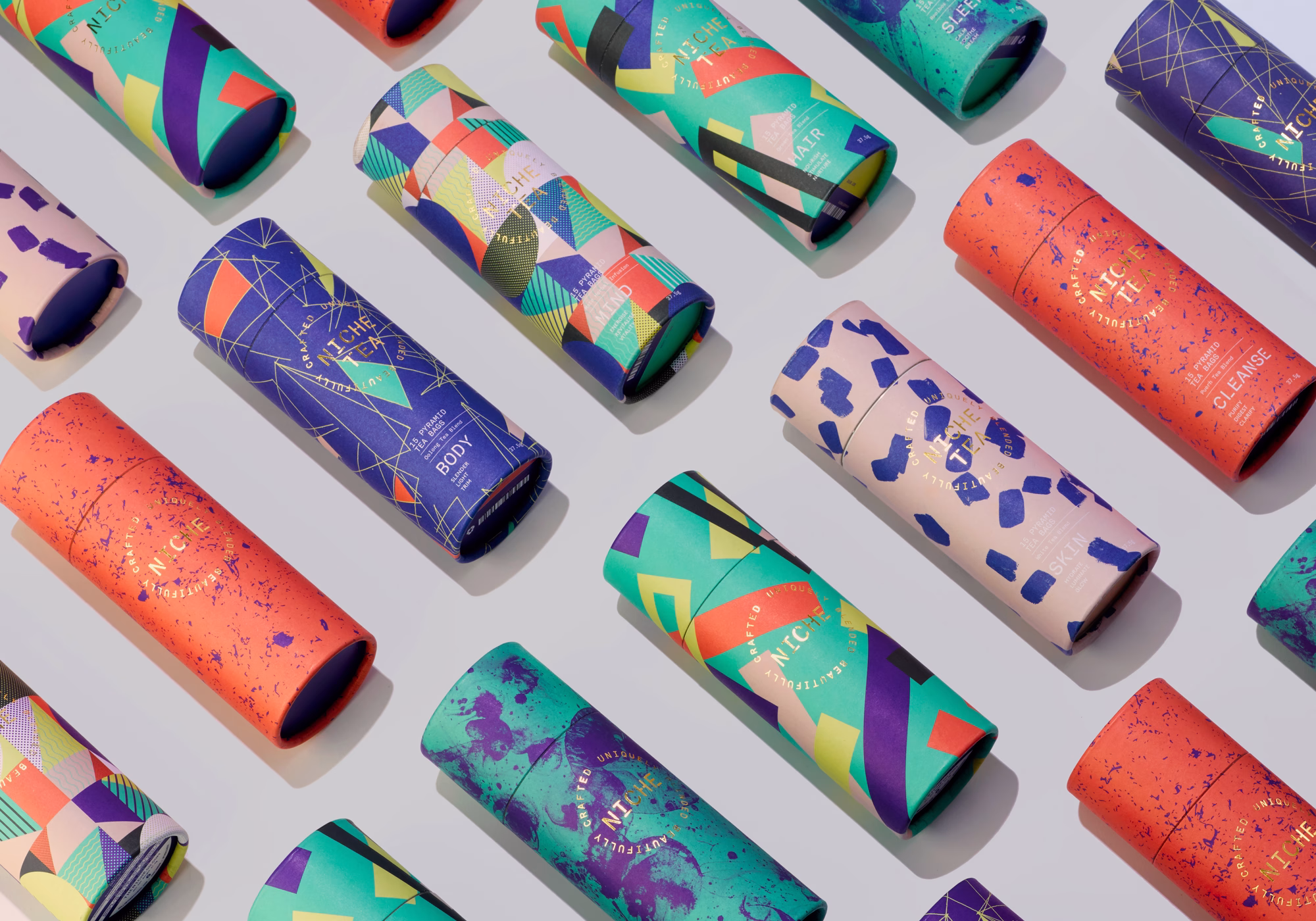A collection of colorful cylindrical packaging with geometric patterns arranged neatly on a light background.