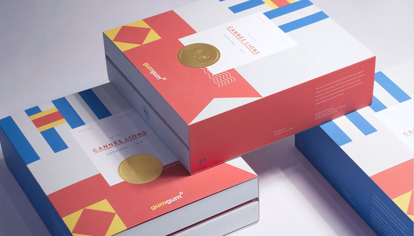 Three boxes with colorful geometric designs, prominently featuring red, blue, and yellow elements, stacked together.