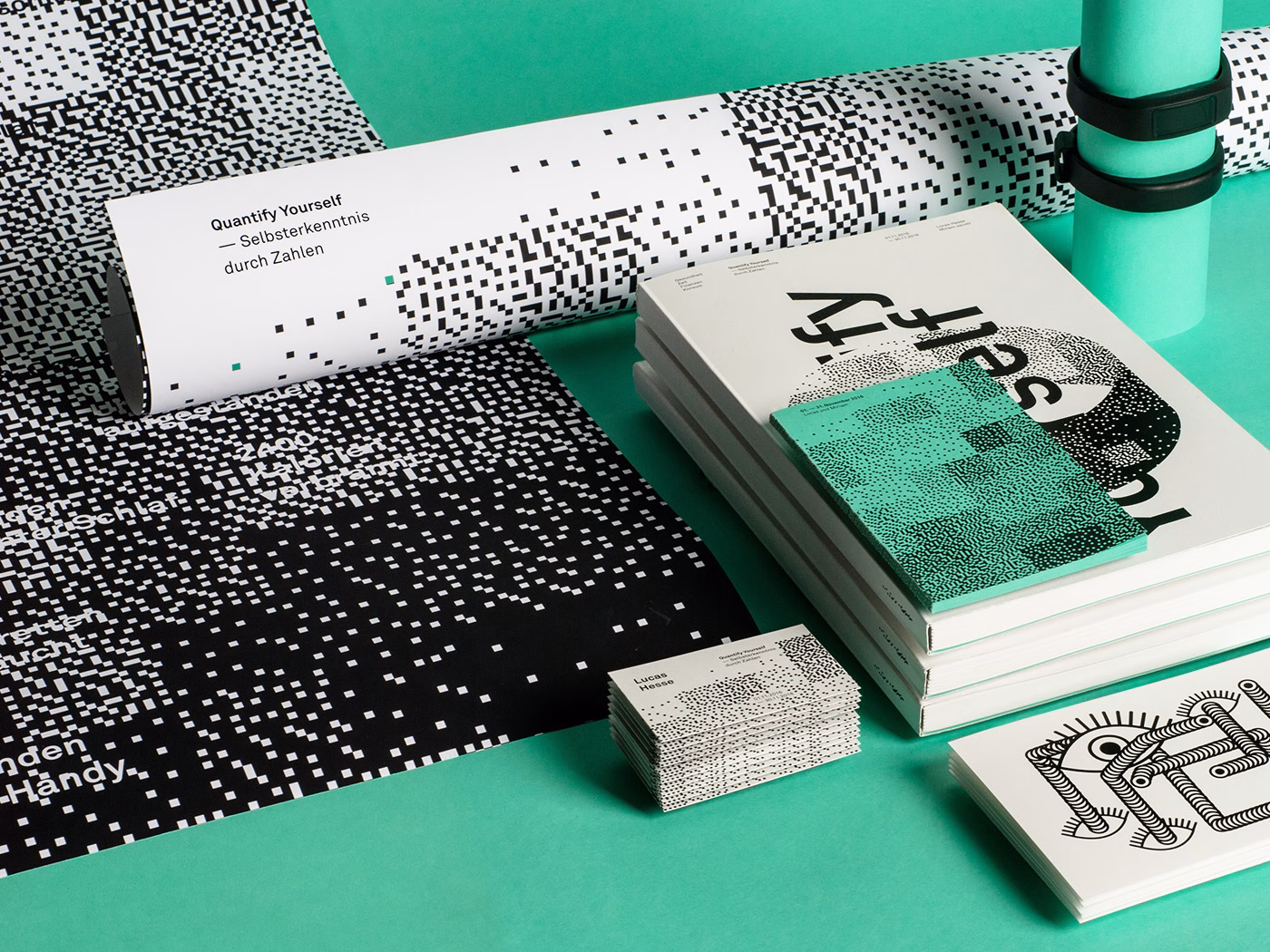 An array of graphic design materials, featuring bold black and white patterns, rests on a vibrant teal surface.