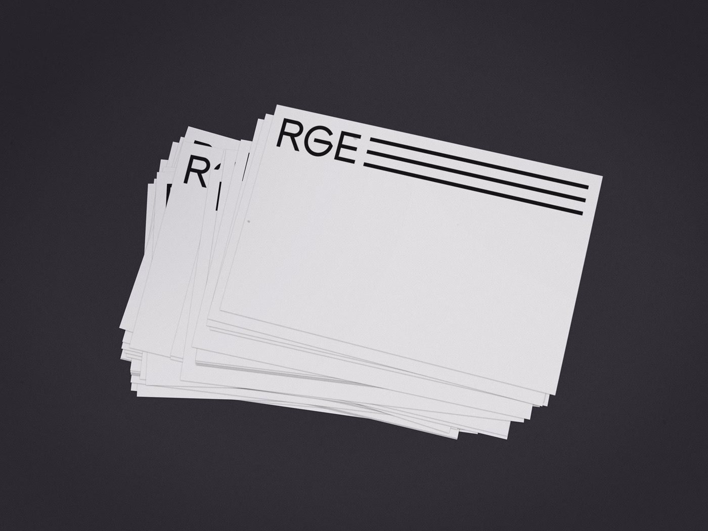 A stack of white cards displays bold black lettering, featuring the letters "RGE" and three horizontal lines.