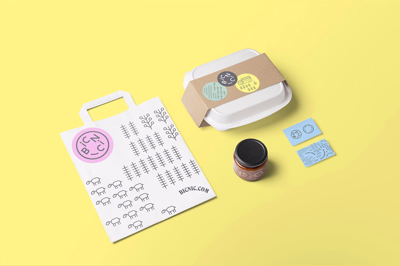 A white paper bag with black illustrations, a food container, a jar, and blue stickers on a yellow background.