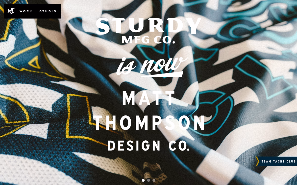 A close-up of folded fabric displaying bold typography in black, white, and teal with a smooth texture.