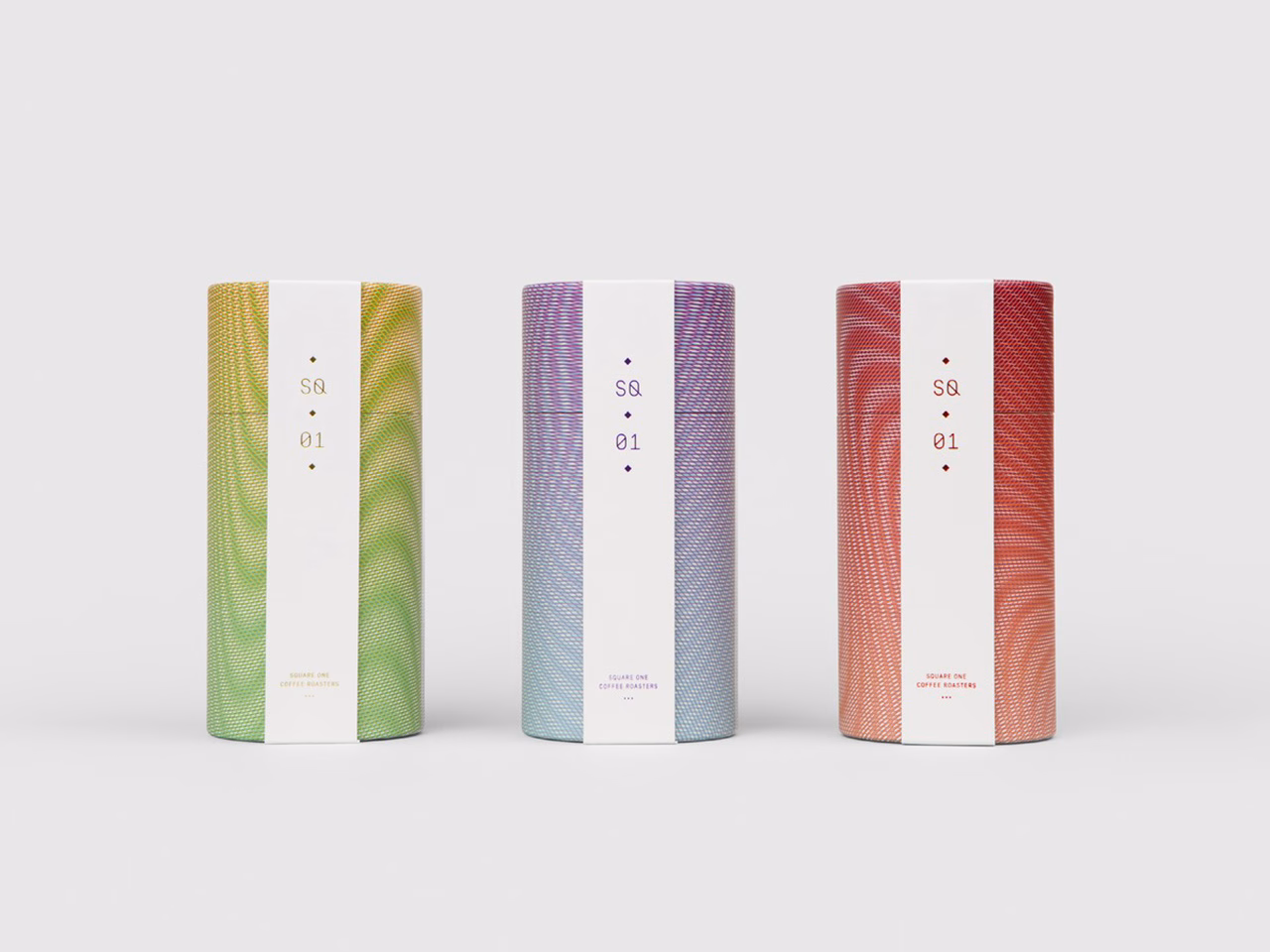 Three cylindrical coffee packaging designs in gradient colors: green, purple, and red, with white text labels.