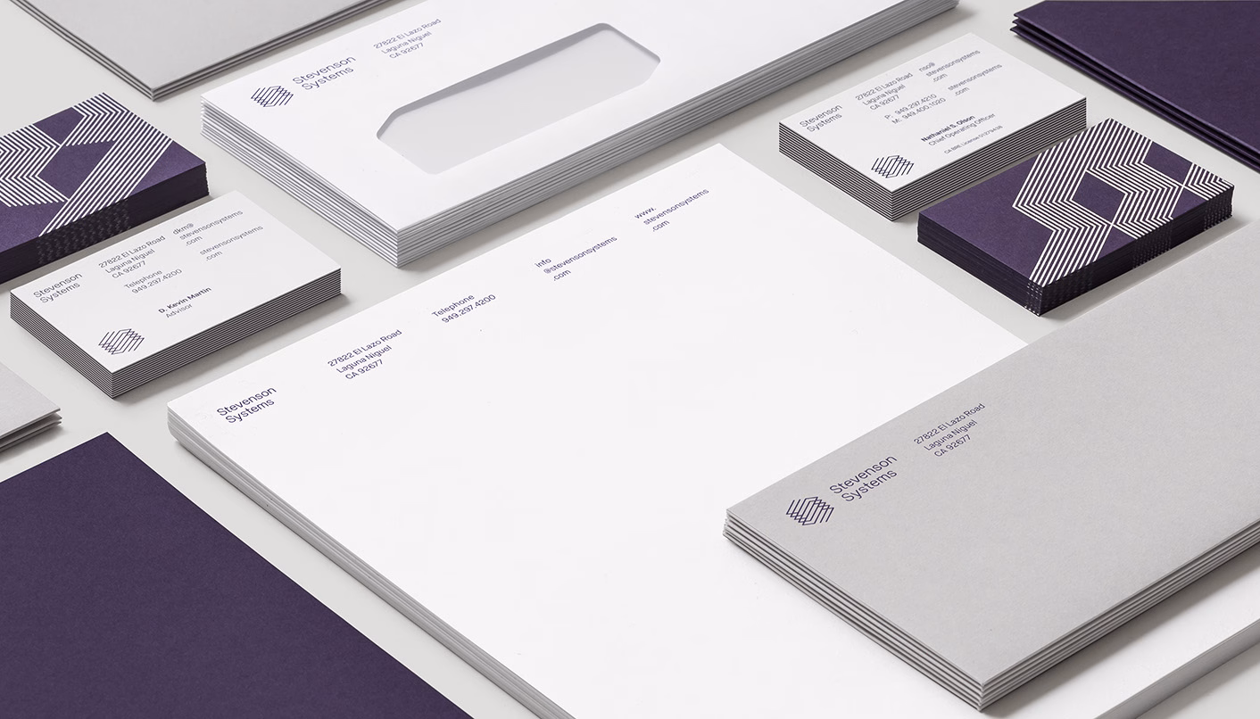 A collection of stationery, including business cards and letterhead, features a modern purple and gray design scheme.