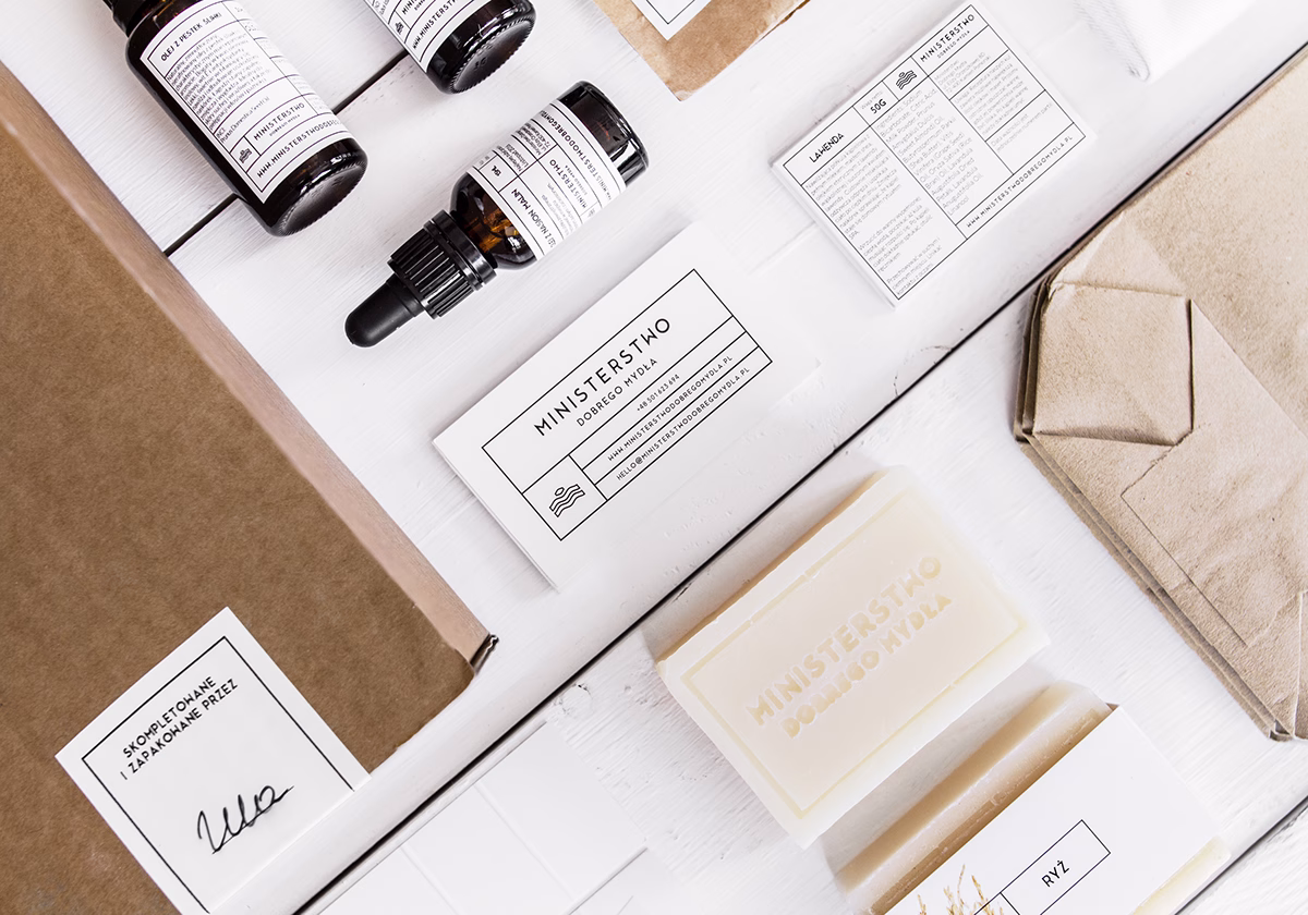An arrangement of skincare products including amber bottles, minimalist packaging, and soap bars on a white surface.
