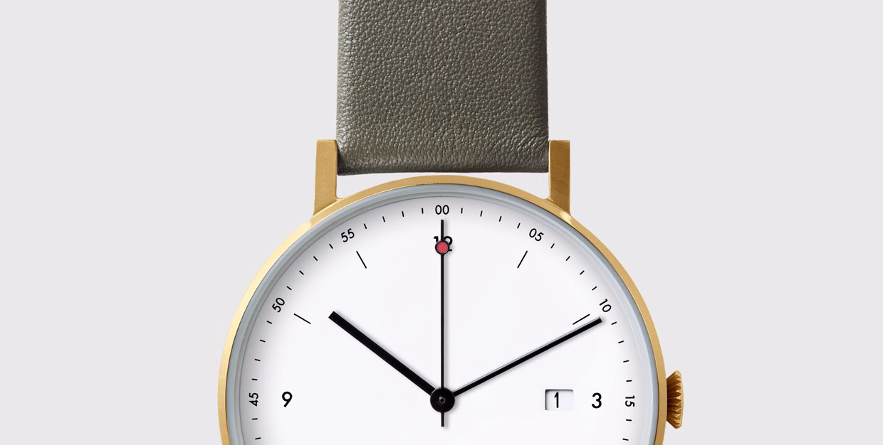A gold watch with a white face, black hands, and a grey leather strap, showing the time at 10:10.