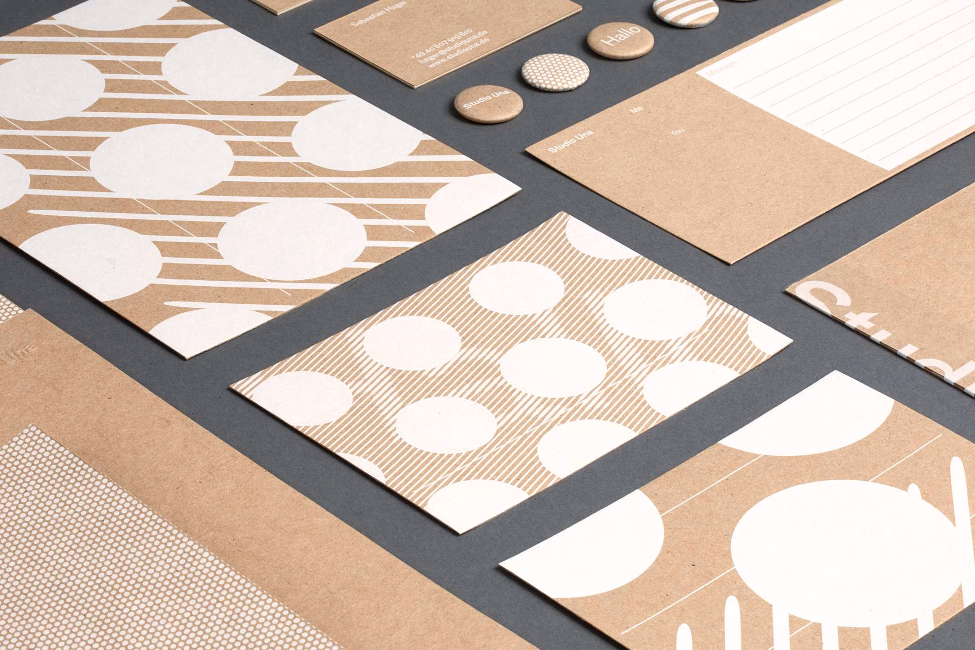 A collection of textured brown stationery featuring white circular patterns and buttons, arranged on a dark surface.