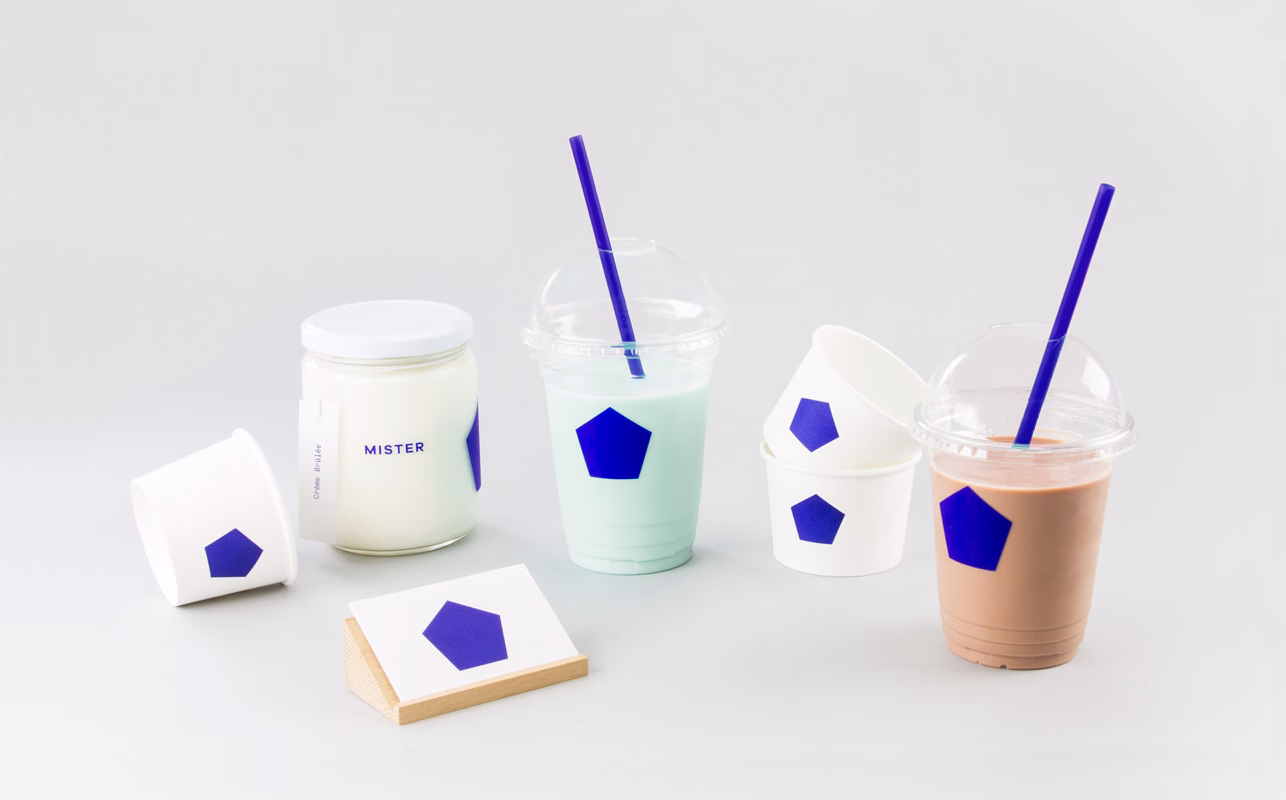 A collection of drinks and containers with purple hexagonal labels on a light gray background.