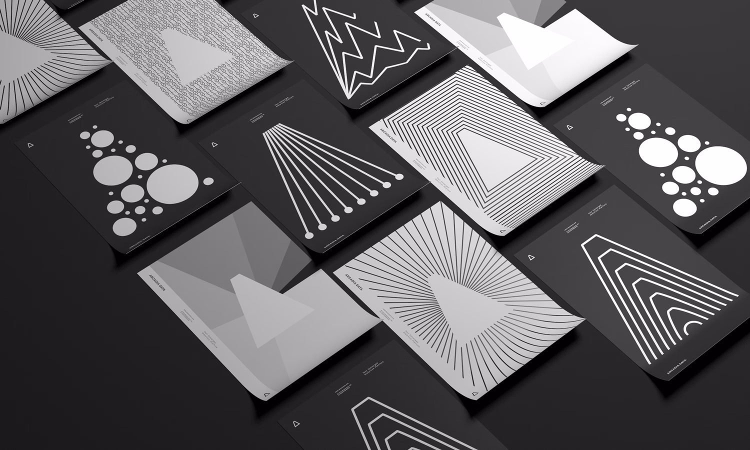 A collection of graphic design posters with geometric patterns in black and white, arranged on a dark surface.