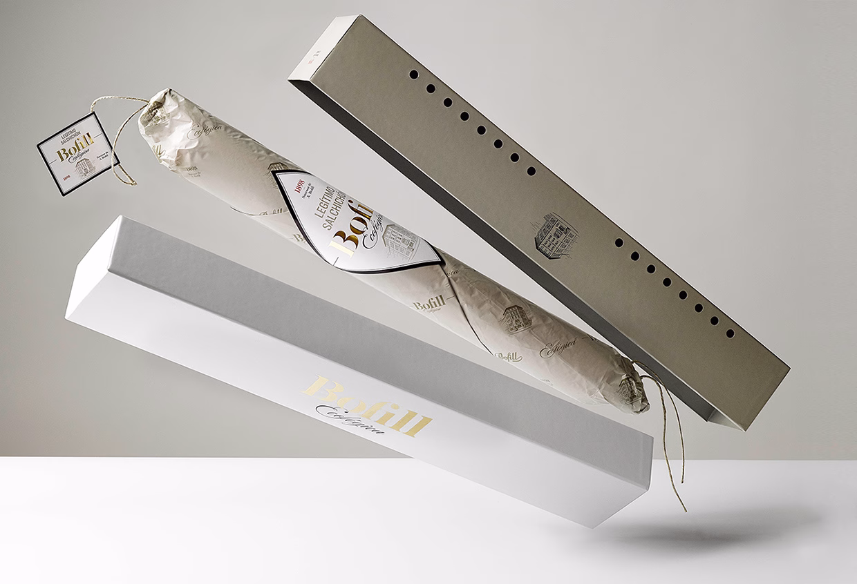 A white and gray packaging set, featuring a wrapped item suspended in midair, showcasing elegant typography.