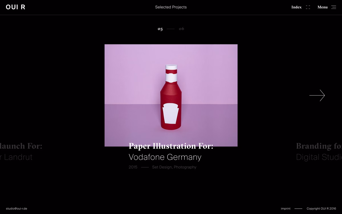 A red bottle resembling ketchup stands against a soft purple background, highlighting its simple paper design.