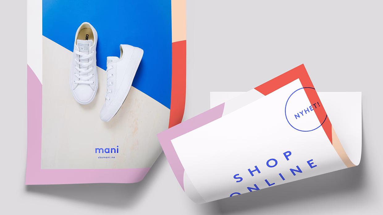 A pair of white sneakers rests on a colorful poster with geometric shapes and bold text.