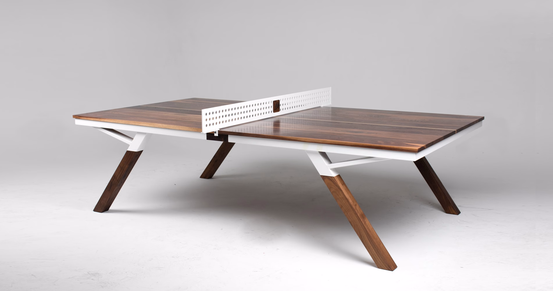 A modern table with a dark wood surface, featuring a white netting divider and angular wooden legs.