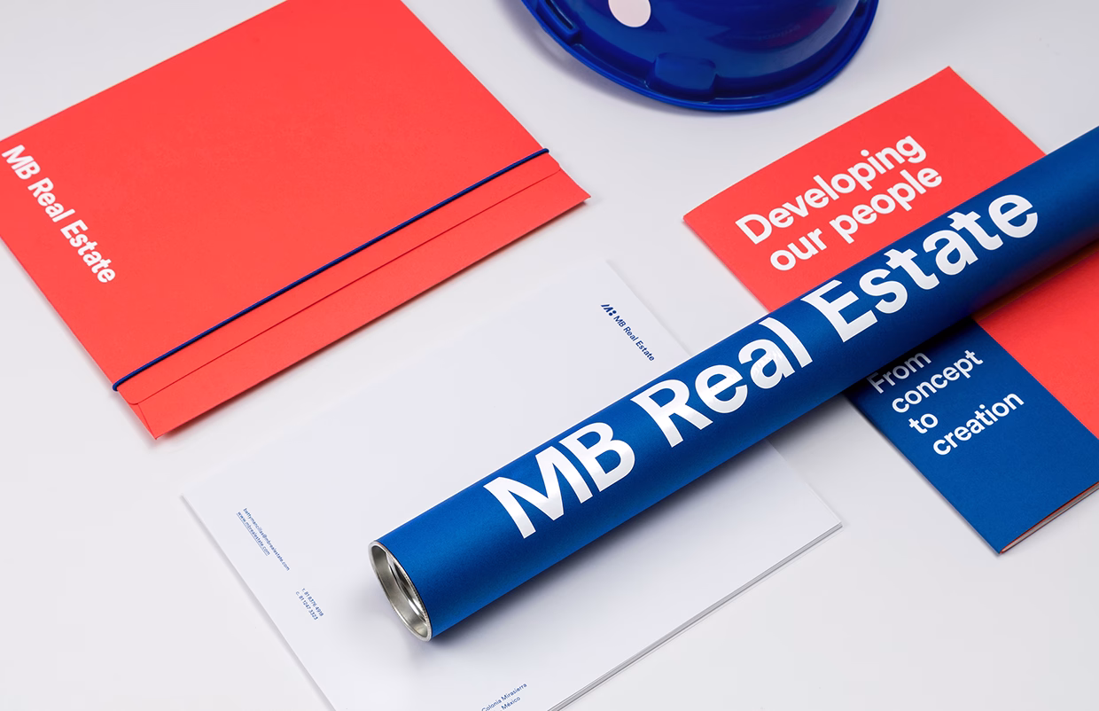 A blue cylindrical object with white text rests on a red and white stationery set, including a blue hard hat.