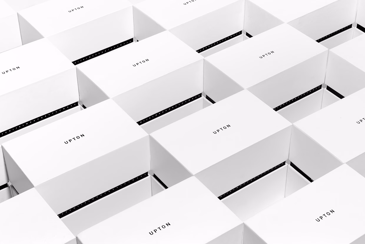 A grid of white boxes, each with the text "UPTON" displayed in simple black typography, creates a minimalistic pattern.