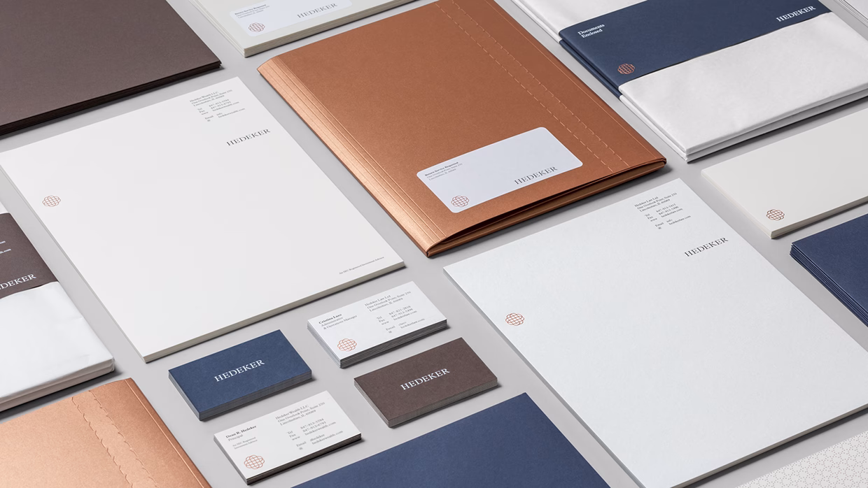 A variety of stationery items arranged neatly, featuring copper, navy, and white colors, with a cohesive branding design.