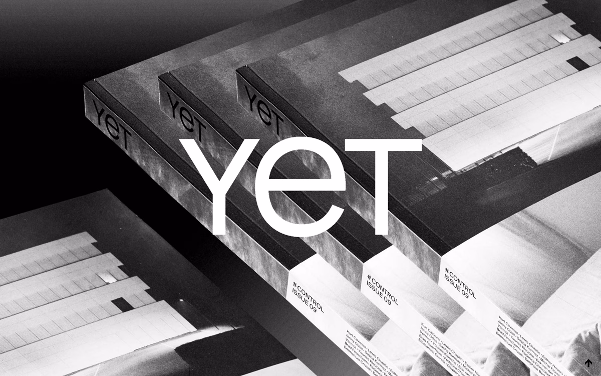 A stack of magazines titled "YET" in bold white typography, featuring black-and-white photographic covers.