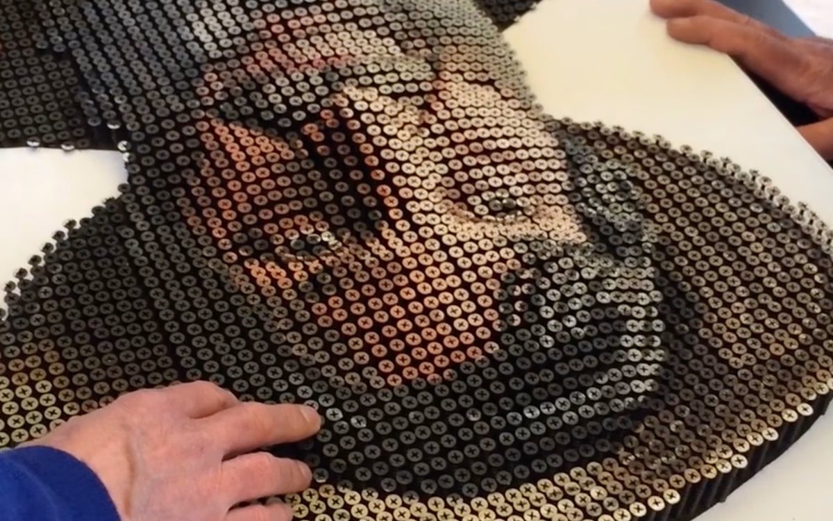 A textured portrait created from a gradient of screws, with hands gently touching the surface.