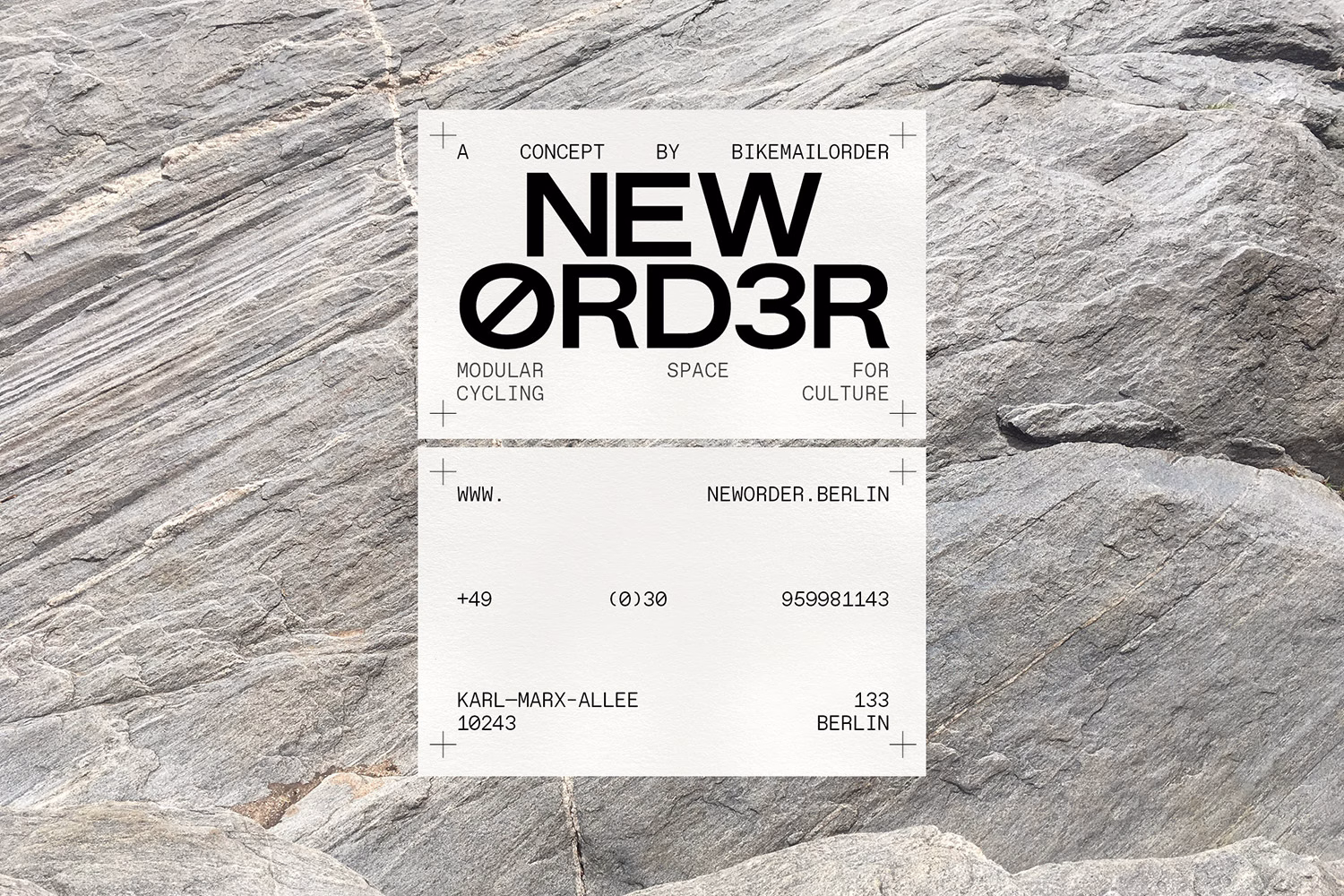 A white card with bold black typography features contact details against a textured gray rock background.