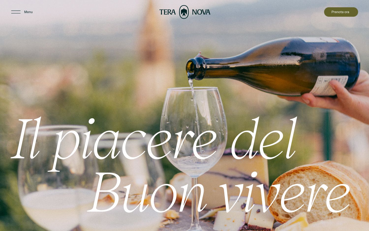 Wine is being poured into a glass with bread and cheese nearby.