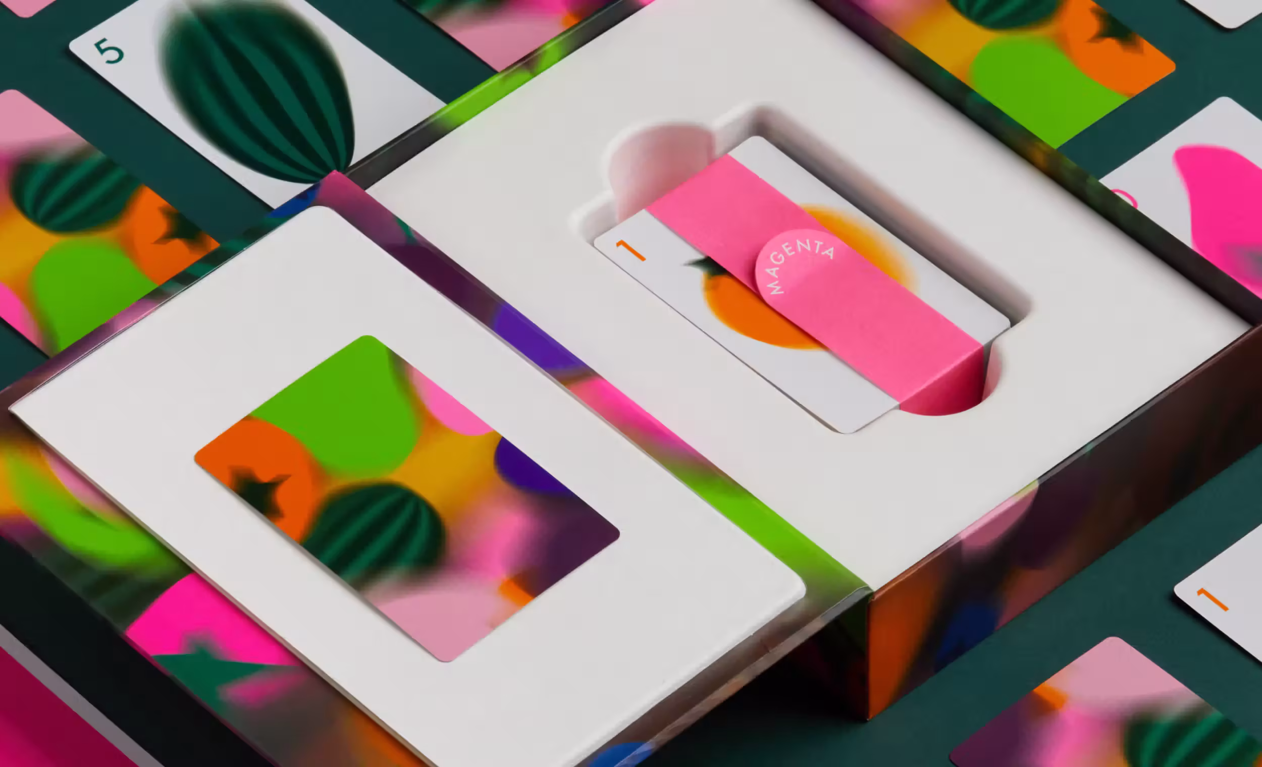 A white box holds colorful cards with abstract designs, featuring a magenta band on one card labeled "MAGENTA."