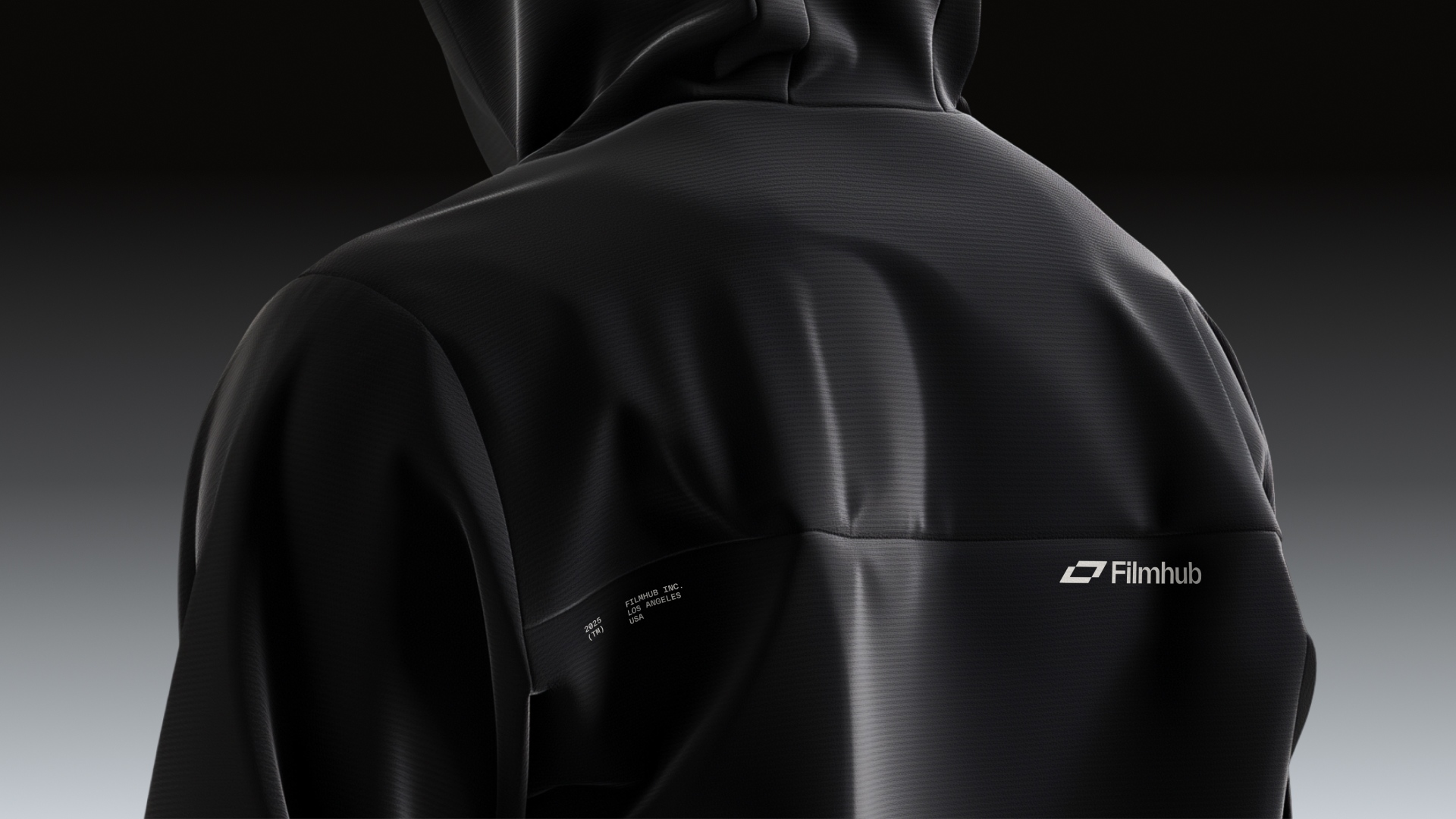 Close-up of a person wearing a black hoodie with "Filmhub" logo on the back.