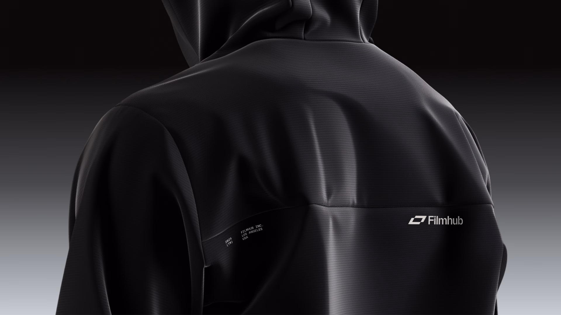 Close-up of a person wearing a black hoodie with "Filmhub" logo on the back.