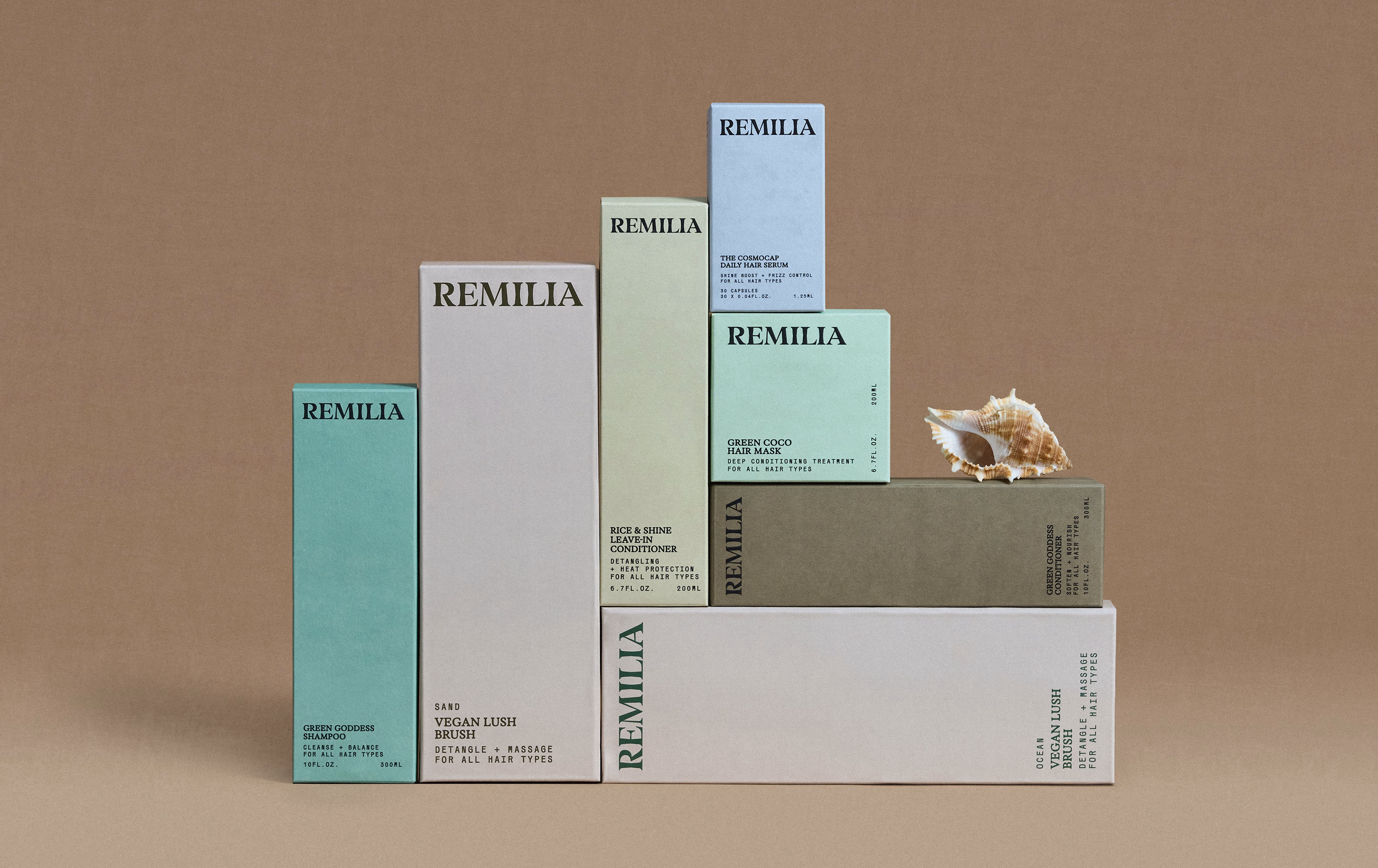 Remilia product boxes stacked with a seashell on a brown background.