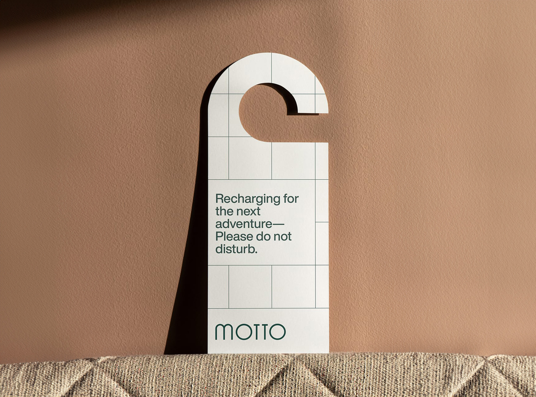 A door hanger on a beige wall reads, "Please do not disturb. Recharging."