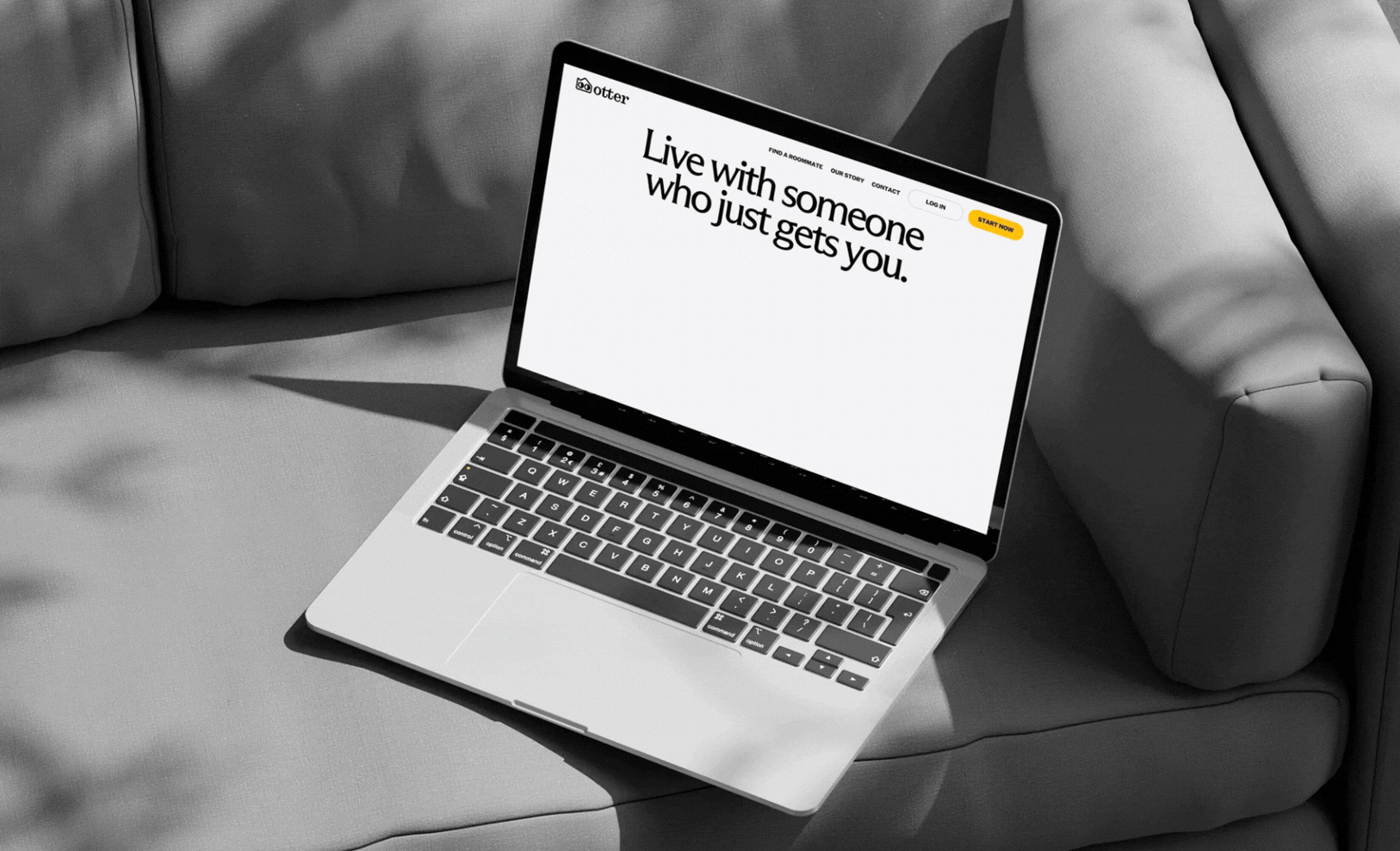 A laptop rests on a light gray couch, displaying the phrase "Live with someone who just gets you" in bold typography.