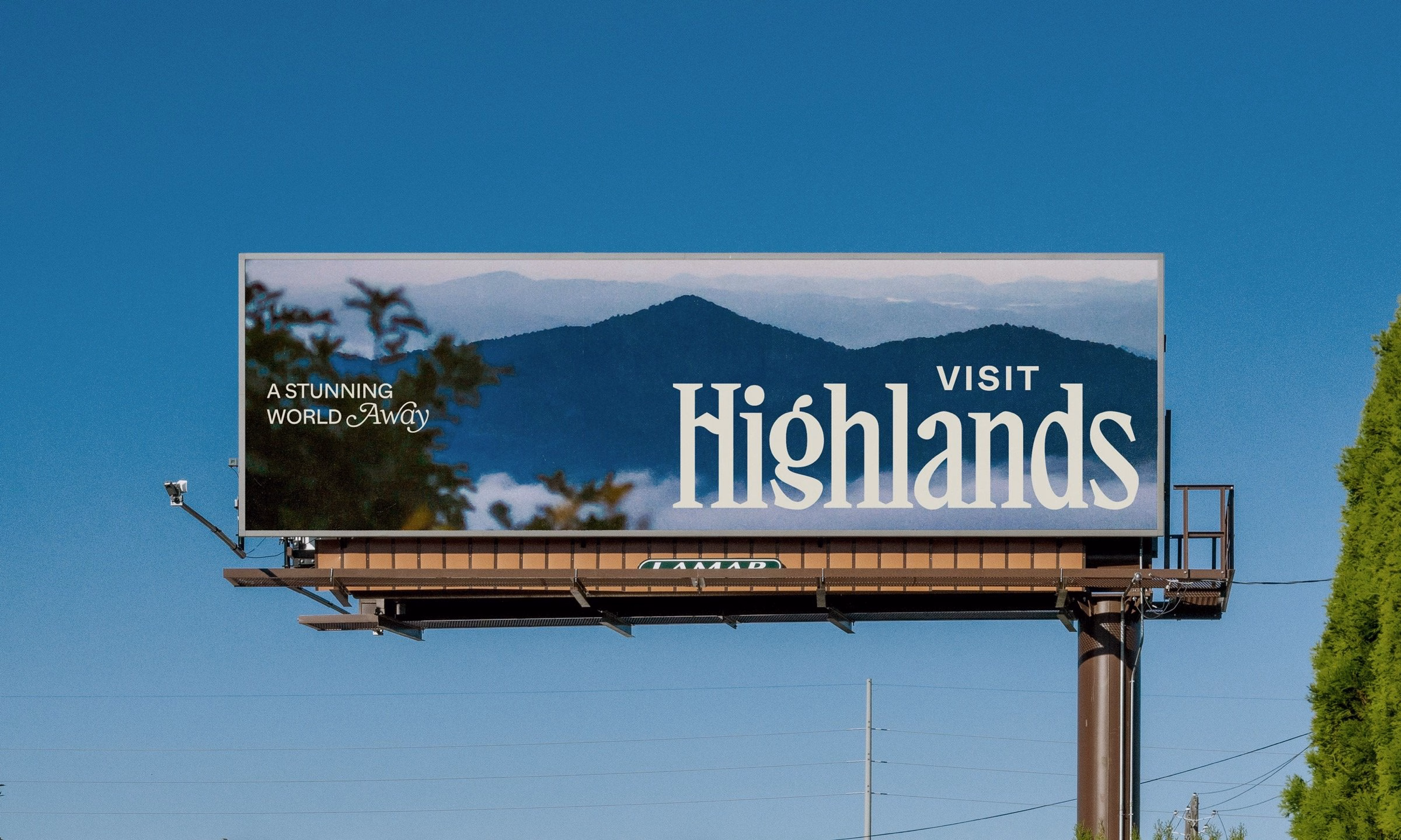 Billboard featuring a mountainous backdrop and elegant typography promoting "Visit Highlands" against a blue sky.