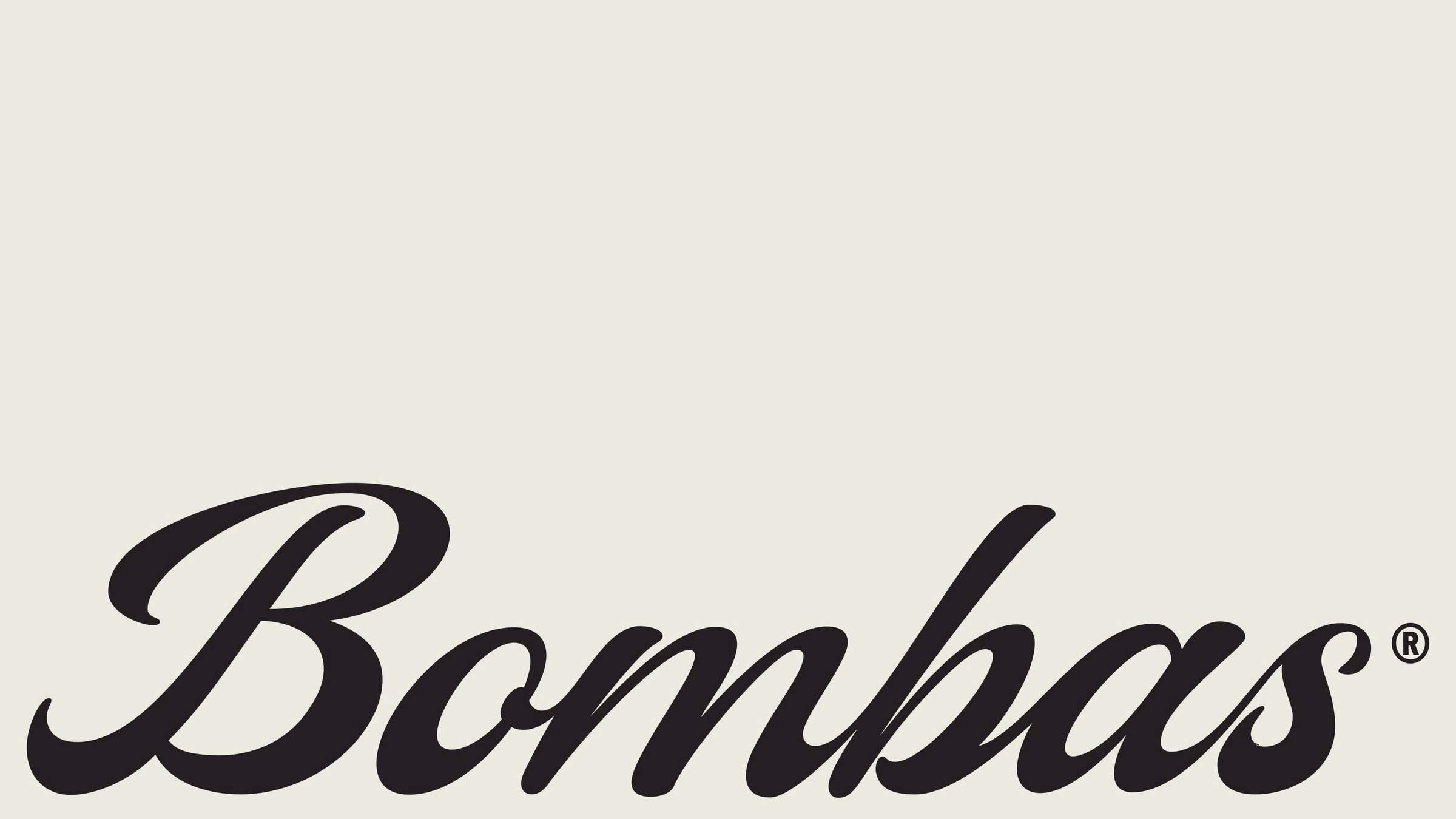 Black cursive lettering of "Bombas" on a soft cream background, emphasizing comfort in brand identity design.
