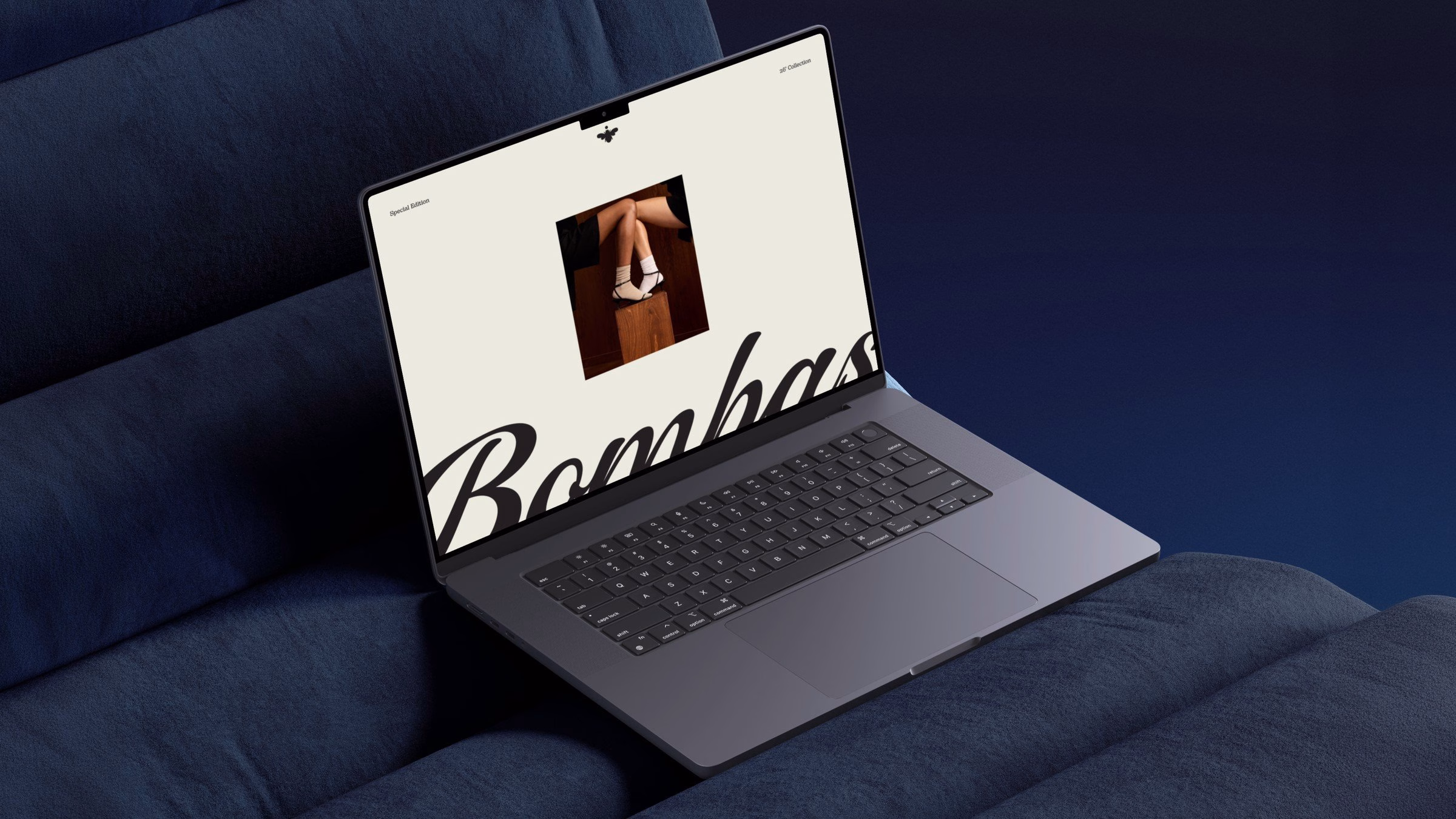 A laptop displays the Bombas website, featuring rounded typography and a soft color palette on a dark blue fabric backdrop.