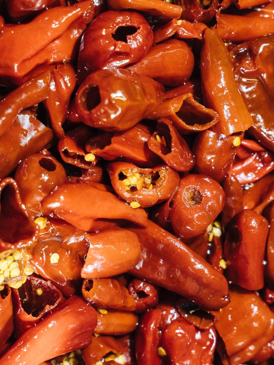 Close-up of vibrant red dried chili peppers, showcasing their glossy texture and distinct shapes for Oraio's design project.