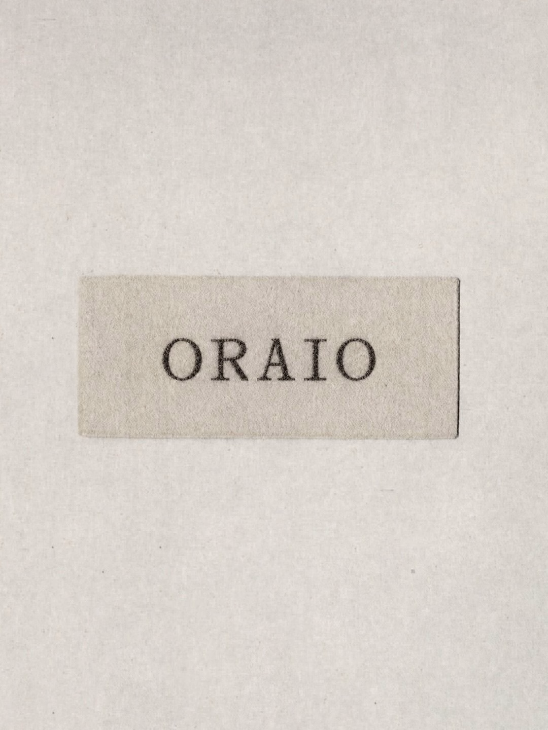 A textured label with the word "ORAIO" printed in a serif font, set against a light gray background.