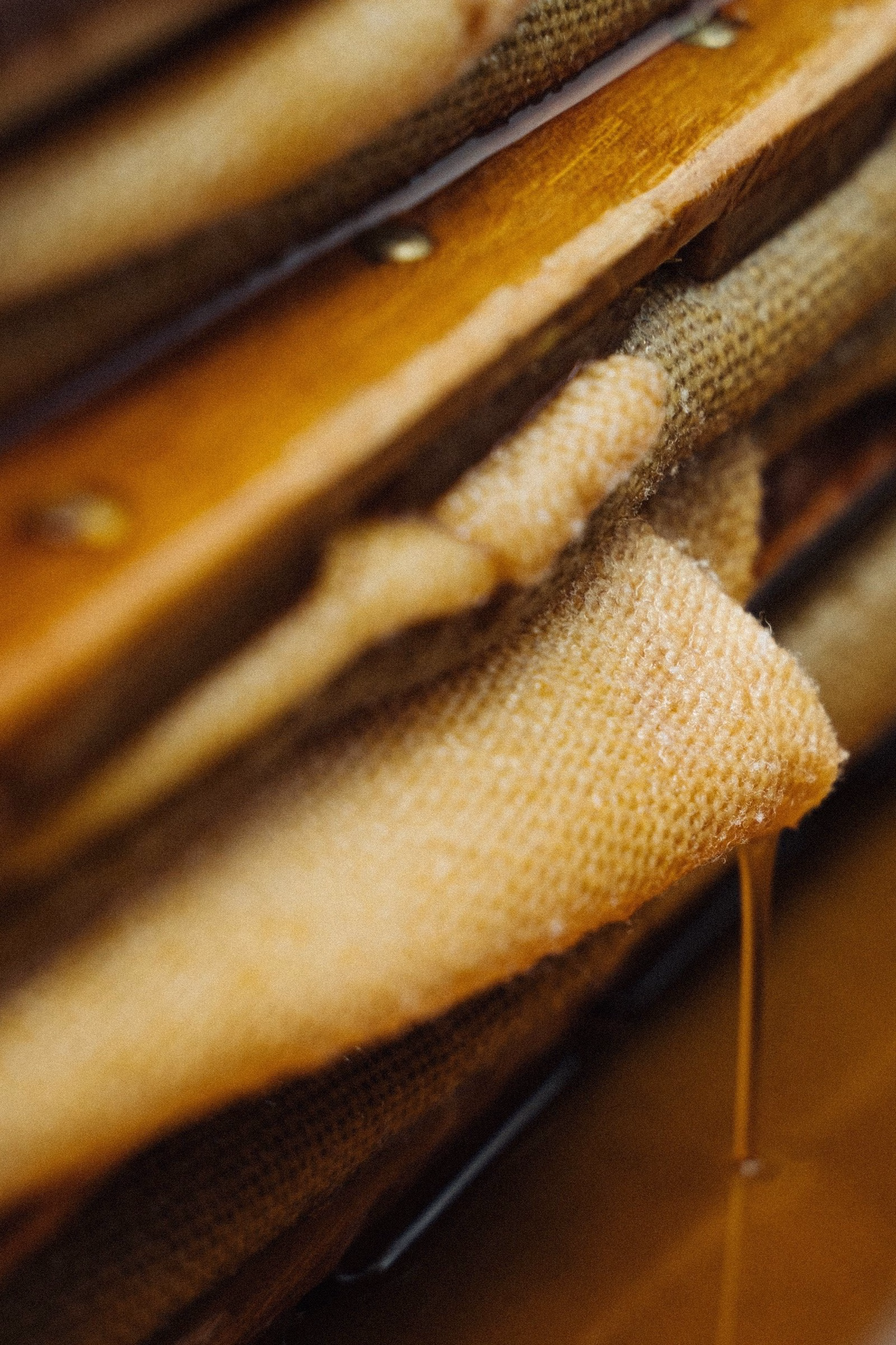 Close-up of layered burlap and wooden slats, showcasing the natural textures and warm tones associated with Oraio's design.