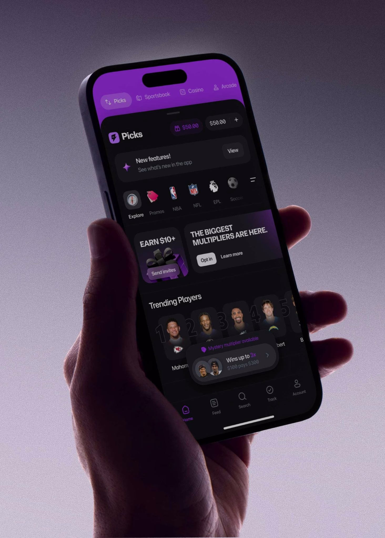 A hand holds a smartphone displaying a dark-themed gaming app with vibrant purple accents and player stats.