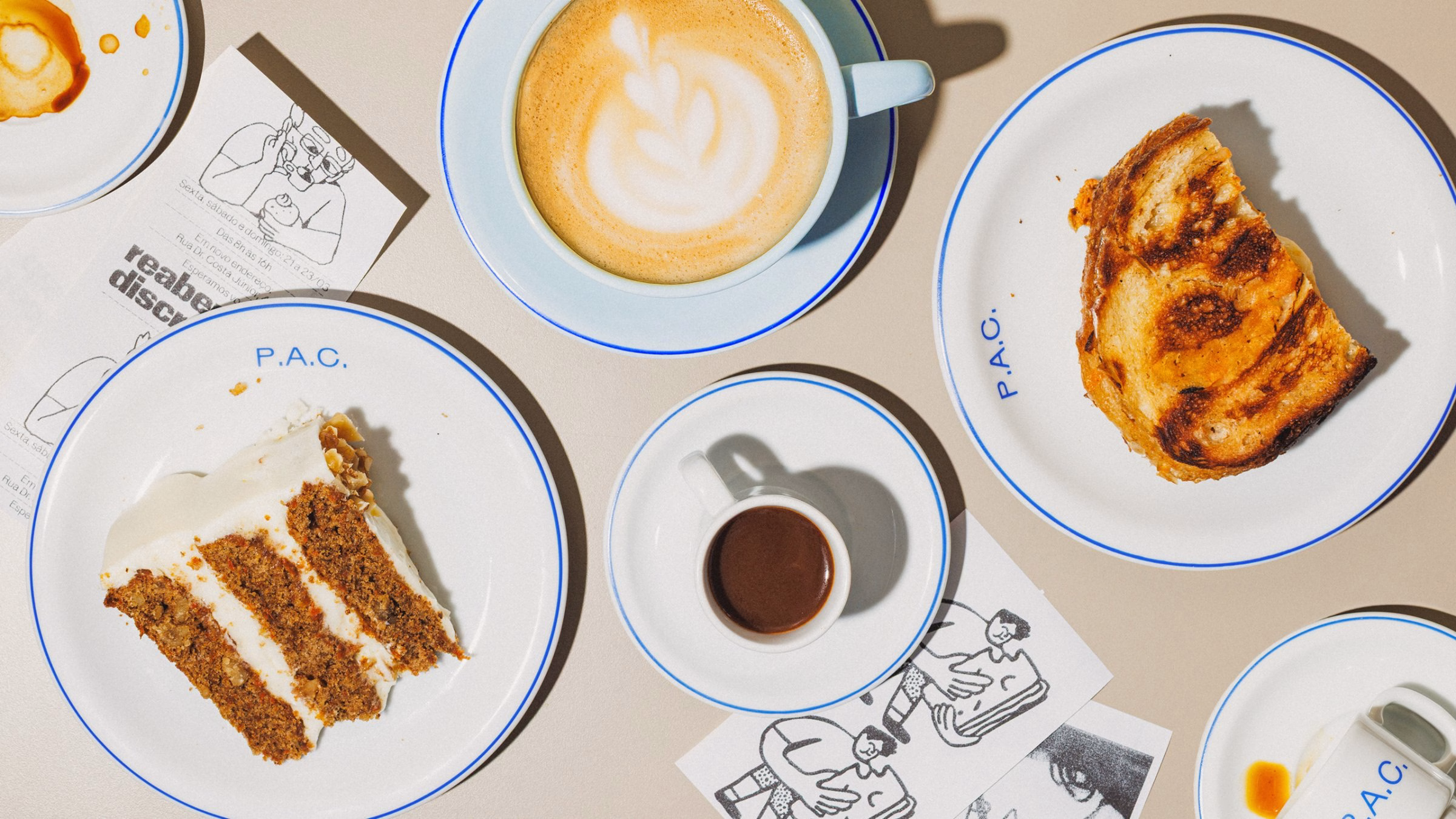 P.A.C. bakery's plates display a slice of cake, toasted bread, and espresso, featuring vibrant blue typography.