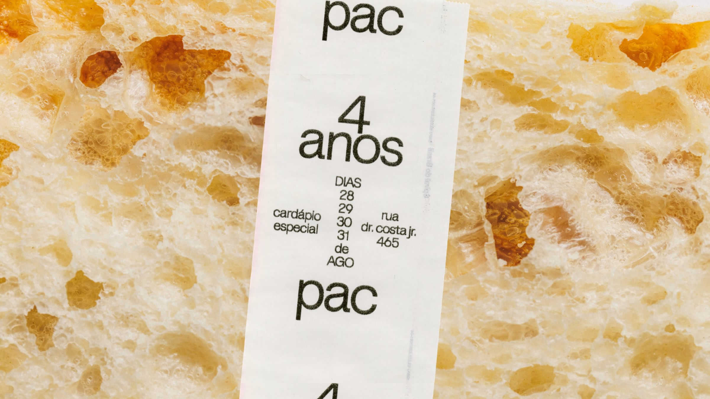 A receipt with bold typography overlaps a textured, golden-brown surface, representing P.A.C. bakery's unique design.