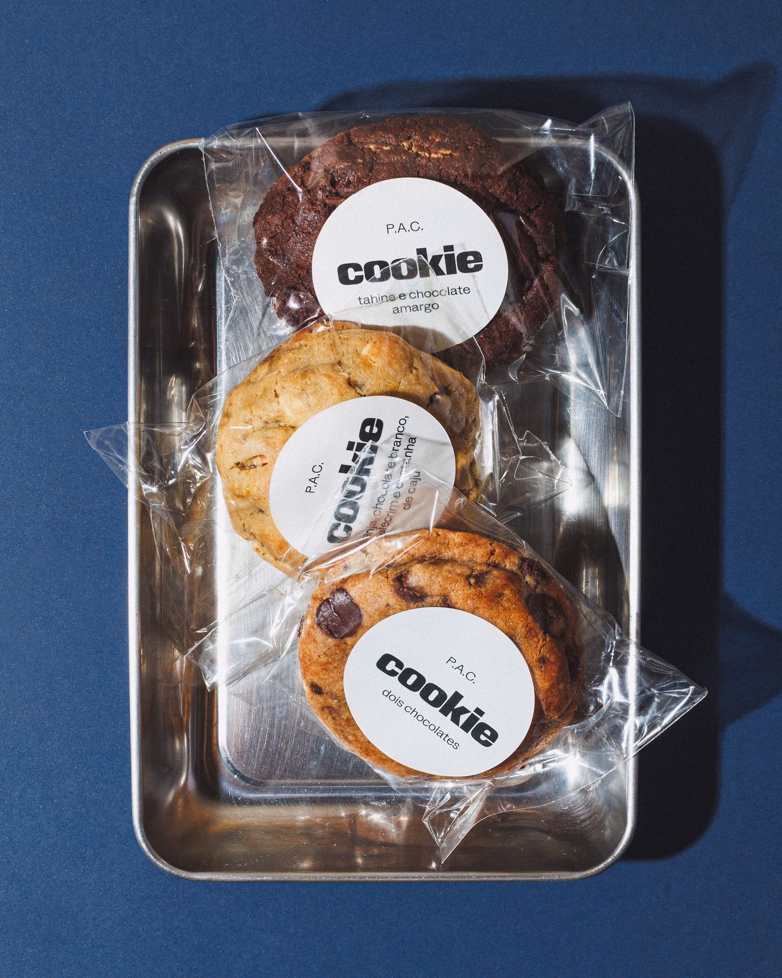 P.A.C. cookies in packaging with round labels on a metal tray