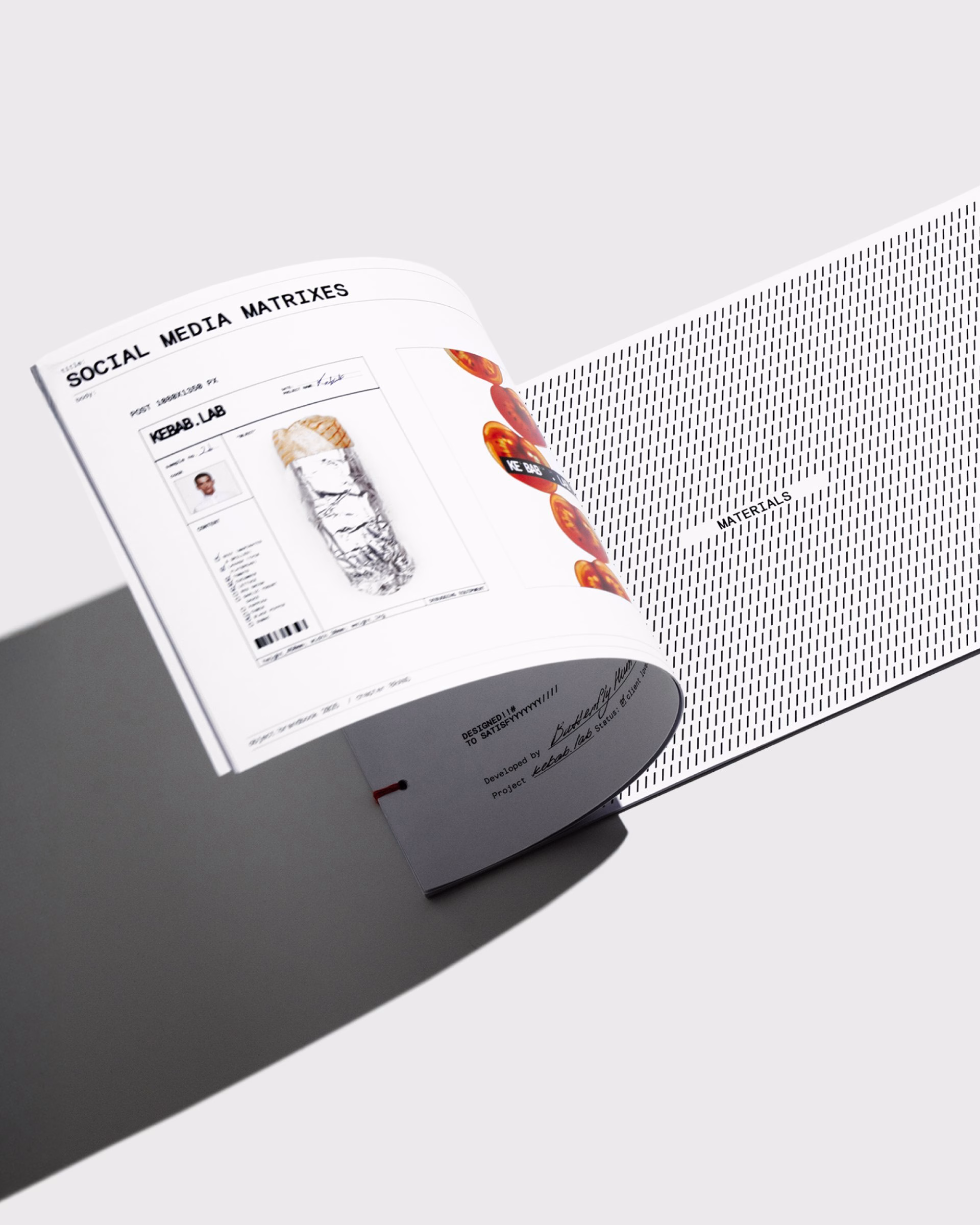 A partially open booklet featuring bold typography, showcasing design elements for Kebab.Lab's branding and packaging.