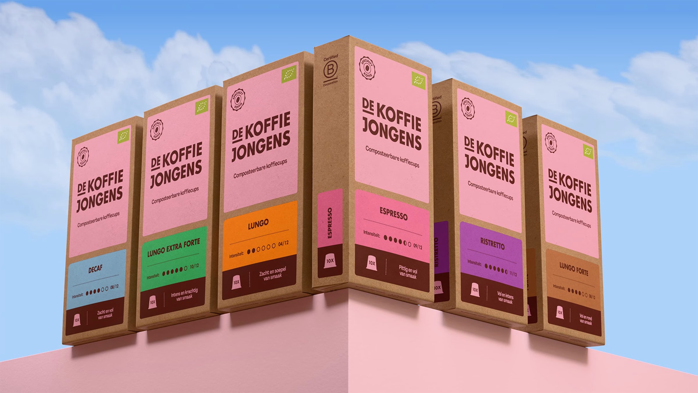 Colorful coffee packaging from De Koffiejongens displayed on a pink shelf, showcasing various flavors and designs.