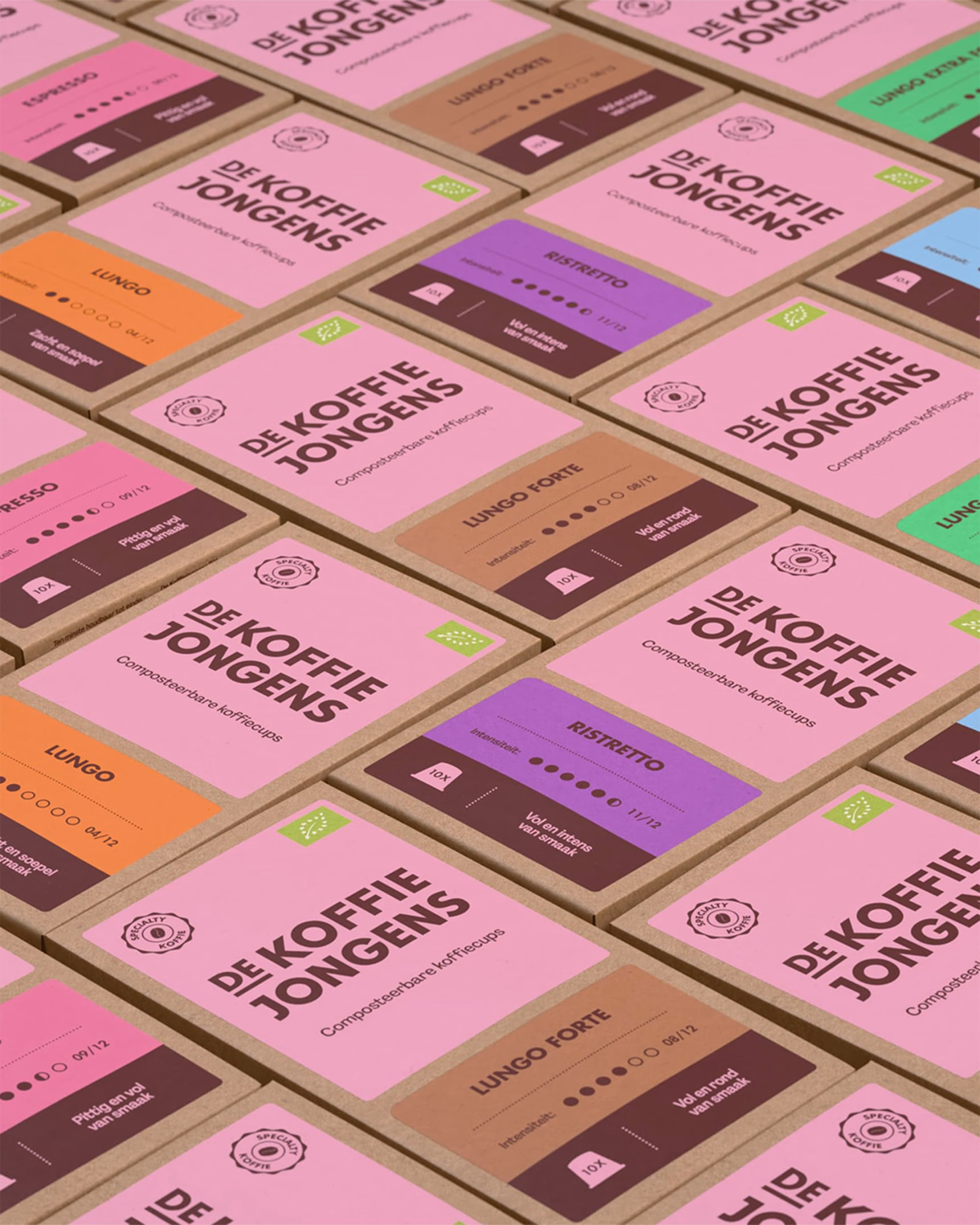 Colorful coffee packaging designs for De Koffiejongens featuring pink and brown labels with bold typography and icons.
