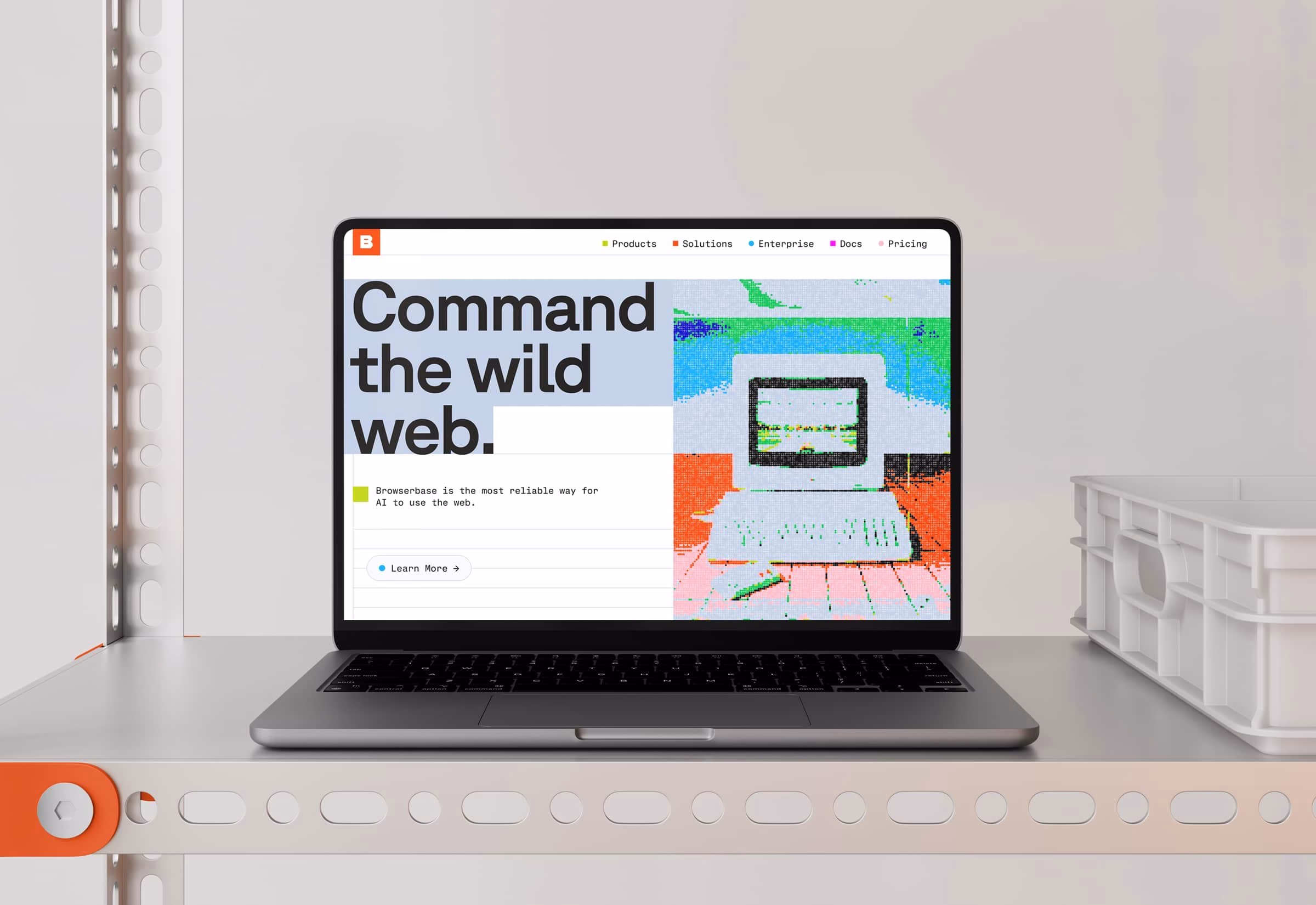 A laptop displays bold typography and vibrant graphics on a clean gray background, showcasing a digital product interface.
